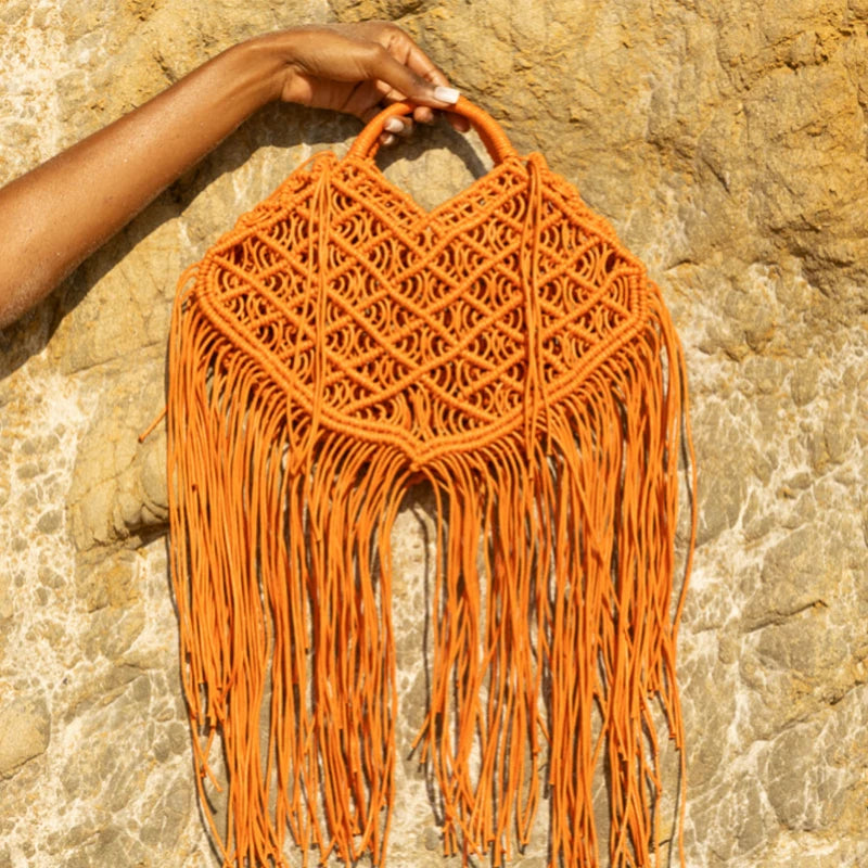holding orange fishnet tote bag