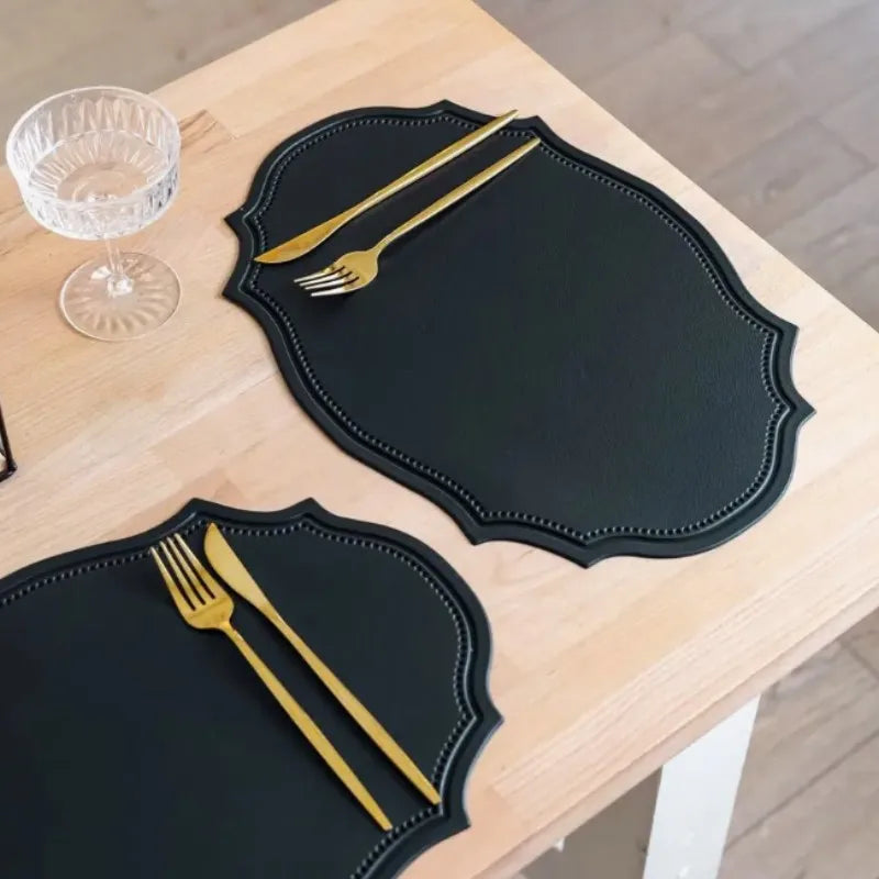 Shaped faux leather PU placemat set in black, pink, and green on a dining table