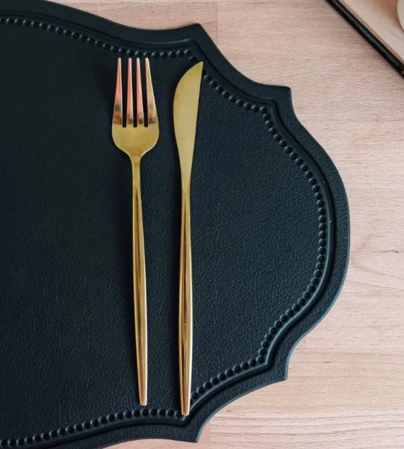 Shaped faux leather PU placemat set in black, pink, and green on a dining table