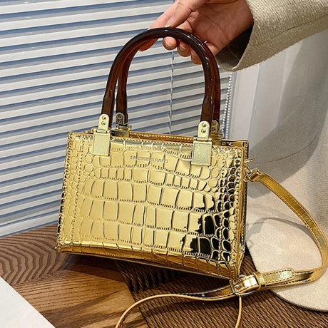 holding gold small square bag
