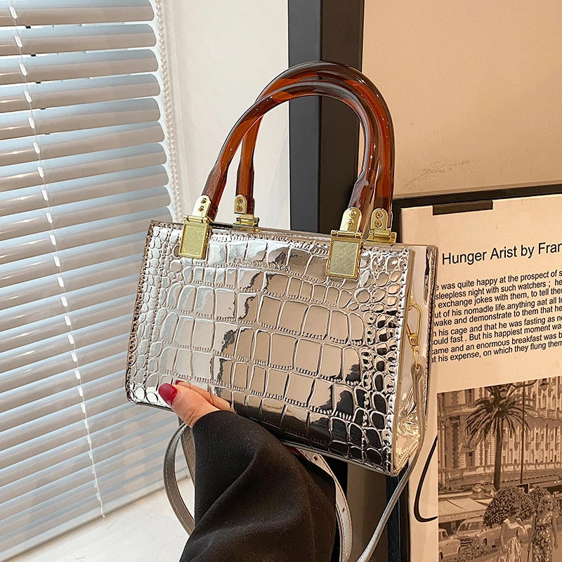 holding silver small square bag