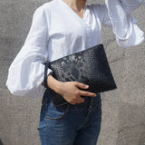 holding black python handbag