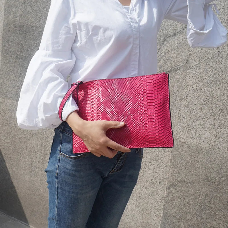 holding pink python handbag