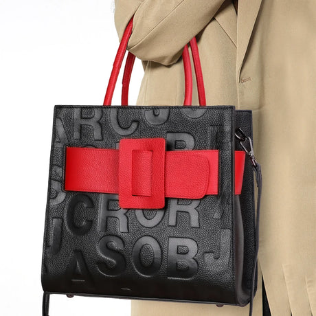 holding black red square handbag