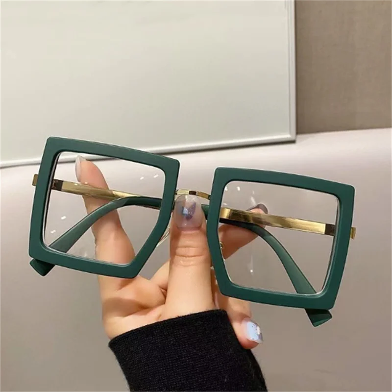 holding green anti blue light glasses