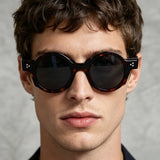 Man wearing vintage round acetate sunglasses with thick tortoiseshell frame