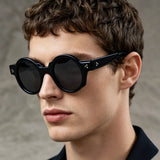 Man wearing vintage round acetate sunglasses with thick tortoiseshell frame