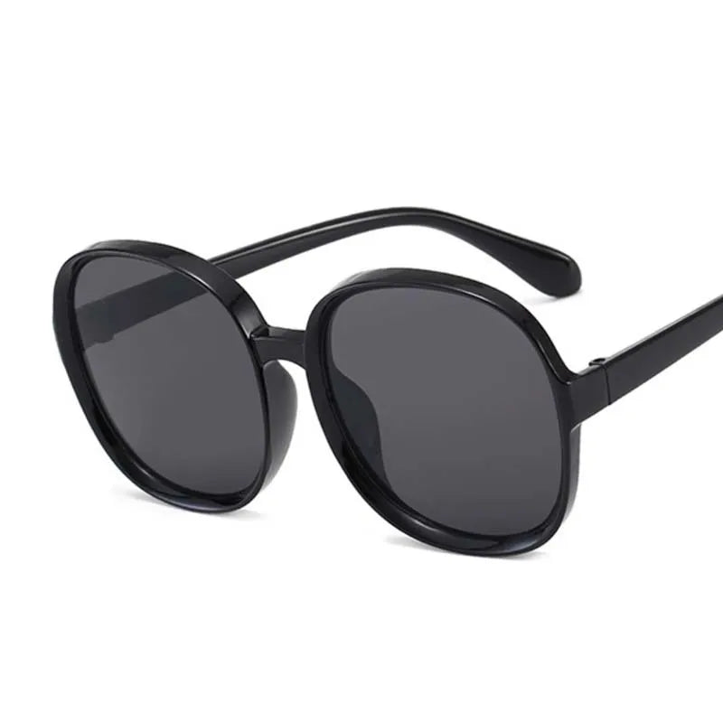 Women’s oversized round vintage sunglasses with plastic frame and luxury designer-inspired style.